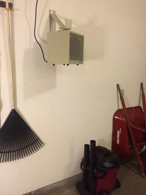 HF5848TC Beefy Garage And Workshop Portable Heater mounted on wall in a garage with fan forced heat, wall bracket visible