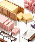 All In One Soap Making Kit For Grown Ups With 2.2 Lb Goat Milk Soap Base, Silicone Loaf Molds, Cutting Box, And 500 Plus Premium DIY Supplies For Easy Beginner Friendly Soap Making, showing cut soap bars, molds, and flowers.