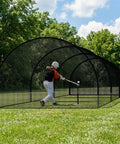 Player practicing in 30Ft Portable Baseball and Softball Batting Cage for Backyard Drills with black polyester mesh and fiberglass poles.