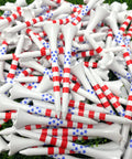 Pile of Two And Three Quarters Inch USA Stars And Stripes Golf Tees Plastic Bulk Pack Of One Hundred For Patriotic Play Made In The USA High Visibility Red White Blue Flag Design Durable Tee It Up At The Same Height Every Hole on grass.