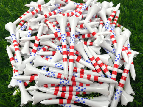 Pile of Two And Three Quarters Inch USA Stars And Stripes Golf Tees Plastic Bulk Pack Of One Hundred For Patriotic Play Made In The USA High Visibility Red White Blue Flag Design Durable Tee It Up At The Same Height Every Hole on grass.