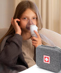 Child using a nebulizer with Travel Ready Hard Shell Medical Case for Portable Nebulizer and Inhaler Accessories nearby.