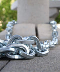 Close-up of Dead Nuts Reliable 10mm Square Steel Chain Zinc Plated Hardened Metal, 10 feet long, ideal for securing and towing.