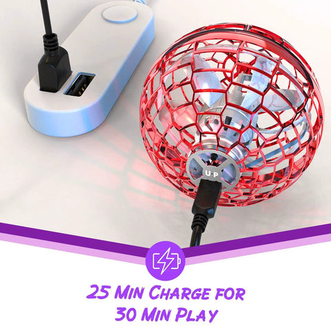 Hand Operated Flying Orb Drone charging via USB cable showing red spherical design with text '25 Min Charge for 30 Min Play'