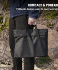 Person holding bag for Portable 20 Inch Stainless Steel Wood Burning Fire Pit With Folding Grill And Carry Bag Ultra Compact Travel Ready Stows To About One Point Two Inches Weighs About Six Lbs Ideal For Camping Picnics Backpacking Beach Trips And Outdoor Heating
