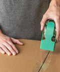 Person using EZ Start Clear Packing Tape Refills For Shipping Moving And Storage 6 Rolls 1.88 Inch By 55 Yards on a box