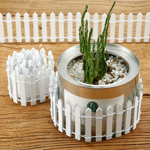 Four Piece 35 Inch Fairy Garden Wood Picket Fence Set For Dollhouse Miniature Village Landscape And DIY Diorama Projects White Color Durable Moisture Proof Great For Tiny Plant Pots And Cute Garden Scenes used around a plant pot