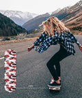Person riding a longboard with Red Camo 2 Pack Grip Tape 9 Inch By 33 Inch Waterproof Longboard Scooter No Slip Bubble Free Griptape design.