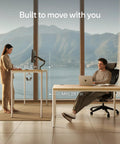 Rock Solid Electric Standing Desk Gliding Smoothly On Ultra Quiet Quad Motors Sixty Three Inch Worktop shown at standing and sitting heights.