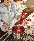 Limited Edition Queen Of Hearts Corded Hand Blender In Bold Passion Red Boasts A Non Slip Soft Grip Handle in use.