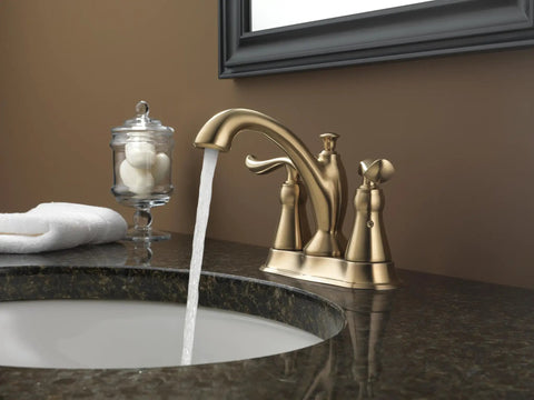 Linden Champagne Bronze Centerset Bathroom Faucet With Diamond Seal Technology installed on dark countertop in modern bathroom.