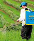 Person using Manual Backpack Sprayer 12L With Fiberglass Lance, 3-Position Pressure Regulator, Padded Straps in agricultural field