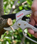 Ratcheting Pruning Shears 8 Inch Heavy Duty Garden Pruner With Anvil Cutter cutting a thick branch outdoors, close-up view.