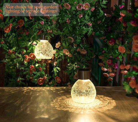4 Pack Solar Lanterns With Shepherd Hooks No Wiring Easy Setup Outdoor Color Changing Crackle Glass 3 Lumens Waterproof Garden Lights For Pathway Backyard Decor glowing on table with flowers