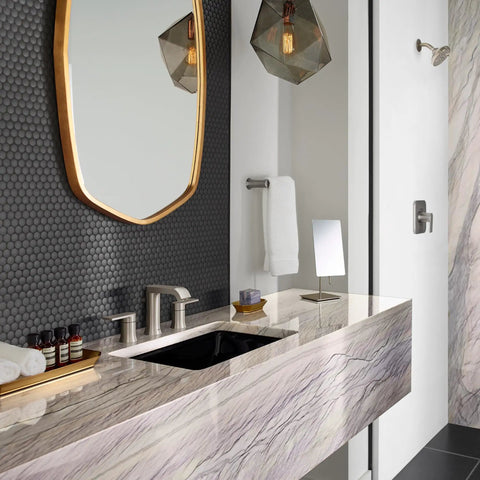 Modern bathroom with marble sink and mirror, showcasing luxury design elements and gray hexagonal tile wall.