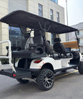 Custom Electric Golf Cart Featuring 48V 150Ah Lithium Battery Plus 6.3kW Motor Off Road Tires Backup Camera Touchscreen Dashboard White Six Seater Weekend Warrior Built Tough Easy Cruising rear view with black leather seating.