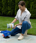Woman using Handheld Lawn Spreader For Seed And Fertilizer, Easy Crank Broadcast Spreader That Covers Up To 1,500 Sq Ft, Blue