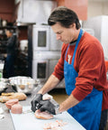 AMMEX X3 black nitrile disposable gloves being worn by a kitchen worker preparing food