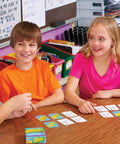 Fast Paced Addition Card Game For Elementary Kids And Teachers at a classroom table with kids and teacher engaging.