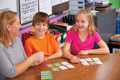 Fast Paced Addition Card Game For Elementary Kids And Teachers at a classroom table with kids and teacher engaging.