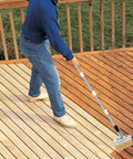 Person using Long Handle Deck Stain Brush With 67 Inch Stainless Steel Extension Pole for staining wood deck