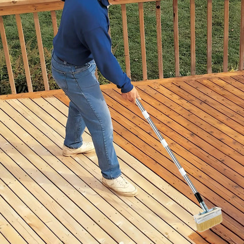 Person using Long Handle Deck Stain Brush With 67 Inch Stainless Steel Extension Pole for staining wood deck