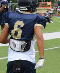 Football player wearing High Impact Football Back Plate For Shoulder Pads Universal Youth And Adult Protection on the field