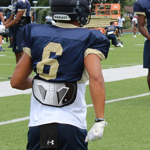 Football player wearing High Impact Football Back Plate For Shoulder Pads Universal Youth And Adult Protection on the field