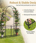 87 Inch Metal Garden Arch With Lockable Gate And Side Shelves Built Tough Arbor Trellis For Climbing Plants Outdoors Includes 6 Ground Stakes Decorative Entrance Archway For Patio And Lawn Black in garden setting with climbing plants and stability stakes.