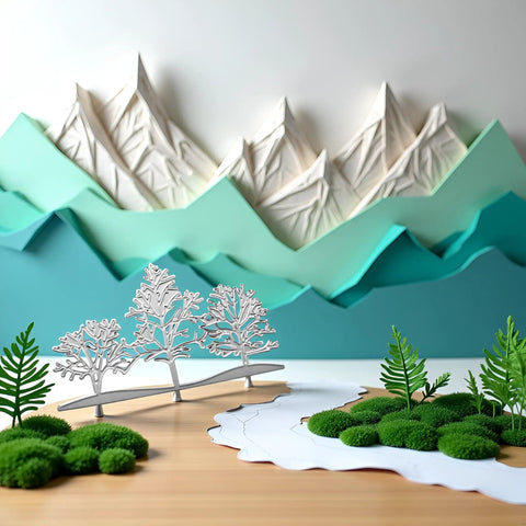 Silver Tree Metal Die Cuts Set For Card Making And Scrapbooking, displayed in a forest scene with layered paper mountains and greenery.
