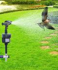 Rock Solid Motion Activated Yard Sprinkler With Adjustable 360 Spray Head spraying water in lawn with a bird flying nearby.