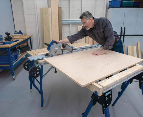 Level Up Your Shop Rig With These Knockout Adaptive Cutting System Extension Brackets That Bolt Right Onto Standard Workbenches Or Portable Project Tables For Quick Setup, worker using track saw on plywood.