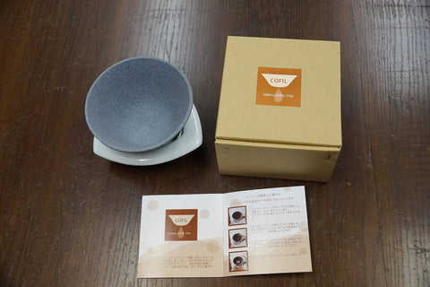 Japanese Ceramic Coffee Filter With Reusable Blue Dripper Stand And Eco Friendly Micropore Design For A Smooth Next Level Pour Over Brew That Truly Hits Different with grey screen and box.
