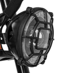 Close-up of the headlight on an Adult Electric Bike In Sleek Black With Sturdy Cargo Rack Featuring Zippy Motor Pedal Assist.