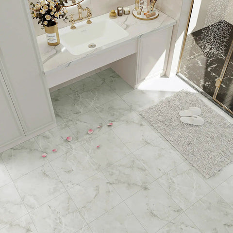 Bathroom scene showcasing marble flooring tiles with rose petals, white countertop, and plush rug beside a glass shower.