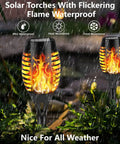 Solar Flickering Flame Outdoor Torch Lights For Garden Decor Waterproof 12 LED Torches in a rainy garden setting.