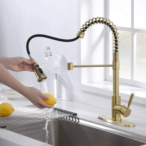 Brushed Gold Kitchen Faucet With Dual Function Pull Out And Pull Down Sprayer shown in use while washing fruit