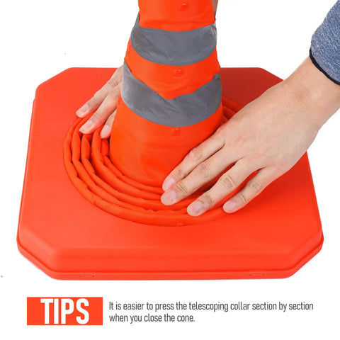 Collapsing orange traffic cone by hand, part of Four Pack 28 Inch Collapsible LED Light Traffic Cones With Reflective Safety Pop Up Design