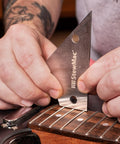 Hands use StewartMac guitar setup essentials with precision fret tool trio metric action gauge fret rocker and fret kisser for exact string height nut saddle and pickup alignment and fret diagnostics pro grade on electric guitar