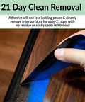 Hand peeling off Blue Painter Tape 4 Rolls 2 Inch Wide Each 55 Yards Total made for quick masking on wood surface.