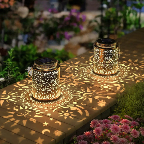 2 Pack Outdoor Solar Lanterns With Hanging Lights Waterproof Metal Sun Moon Star Pattern In Gold Finish on garden table