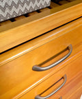 Custom Cut Wall Mounted Closet Organizer System Featuring Heavy Duty Wooden Shelving And Four Deep Soft Close Drawers With Slick Sliding Tracks Crafted From Pure Maple Wood For Top Shelf Walk In Storage close-up view of smooth maple wood drawers with silver handles