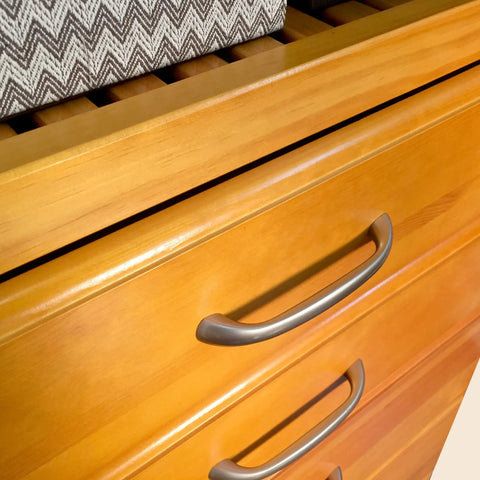 Custom Cut Wall Mounted Closet Organizer System Featuring Heavy Duty Wooden Shelving And Four Deep Soft Close Drawers With Slick Sliding Tracks Crafted From Pure Maple Wood For Top Shelf Walk In Storage close-up view of smooth maple wood drawers with silver handles
