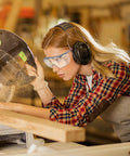 Woman in plaid shirt using a saw, wearing Over Glasses Safety Goggles With Anti Fog And Scratch Resistant Lenses ANSI Z87 Certified.