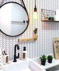 Bathroom with Black And White Peel And Stick Wallpaper Geometric Herringbone Vinyl Self Adhesive Contact Paper, round mirror, and plants.