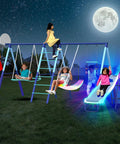 7-In-1 Metal Swing Set With 3 Swings, Climbing Net And Ladder, Basketball Hoop, 5-Ft Blow Molded Slide, 700 Lb Capacity, Yellow And Blue at night