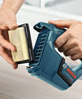 Person handling a 12V Max Hand Vacuum Bare Tool For Quick Jobsite Cleanup With Ultra Lightweight Design, High Power Suction, Flat Filter Boosting Canister Capacity.