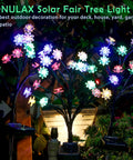 Decorative solar LED tree lights in a garden setting at night, featuring multicolored blossoms and ambient glow.