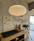 Large White Chinese Paper Ceiling Lamp Shade And Oval Pendant Light Cover With Vintage Round Chandelier Lantern Design hanging in a cozy living space.