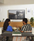Couple enjoying music with Era 100 SL Dope Compact Microphone Free Wireless Speaker With WiFi Bluetooth in living room setup.